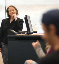 Dr. Barbara Tucker, professor of Communication, smiling and watching students.